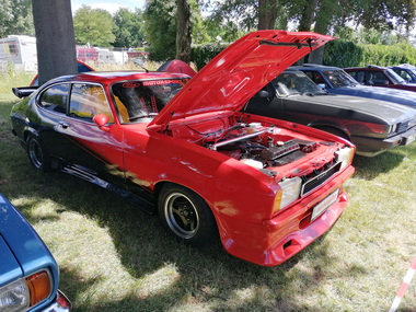 Offene Motorhauben mit gepflegtem Motorraum locken Zuschauer an
Open bonnets with well-maintained engine compartments attract spectators
Les capots ouverts avec un compartiment moteur bien entretenu attirent les spectateurs
